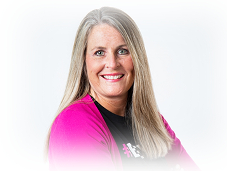 Deeanne King smiling and wearing a magenta cardigan