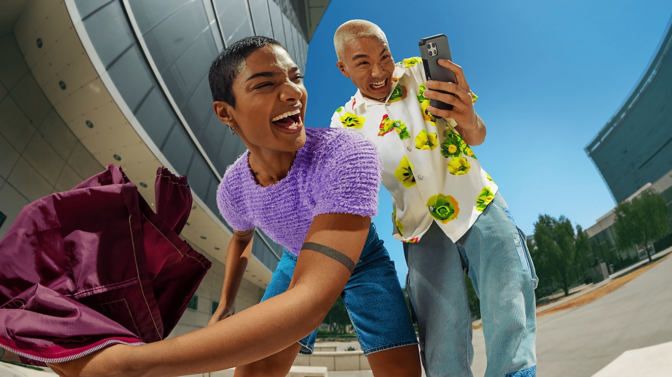 Two people having fun and looking at cellphone