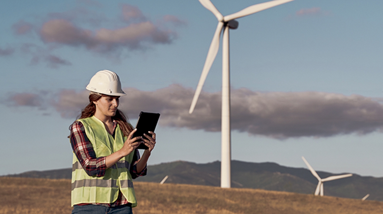 An engineer uses a tablet at a wind farm.