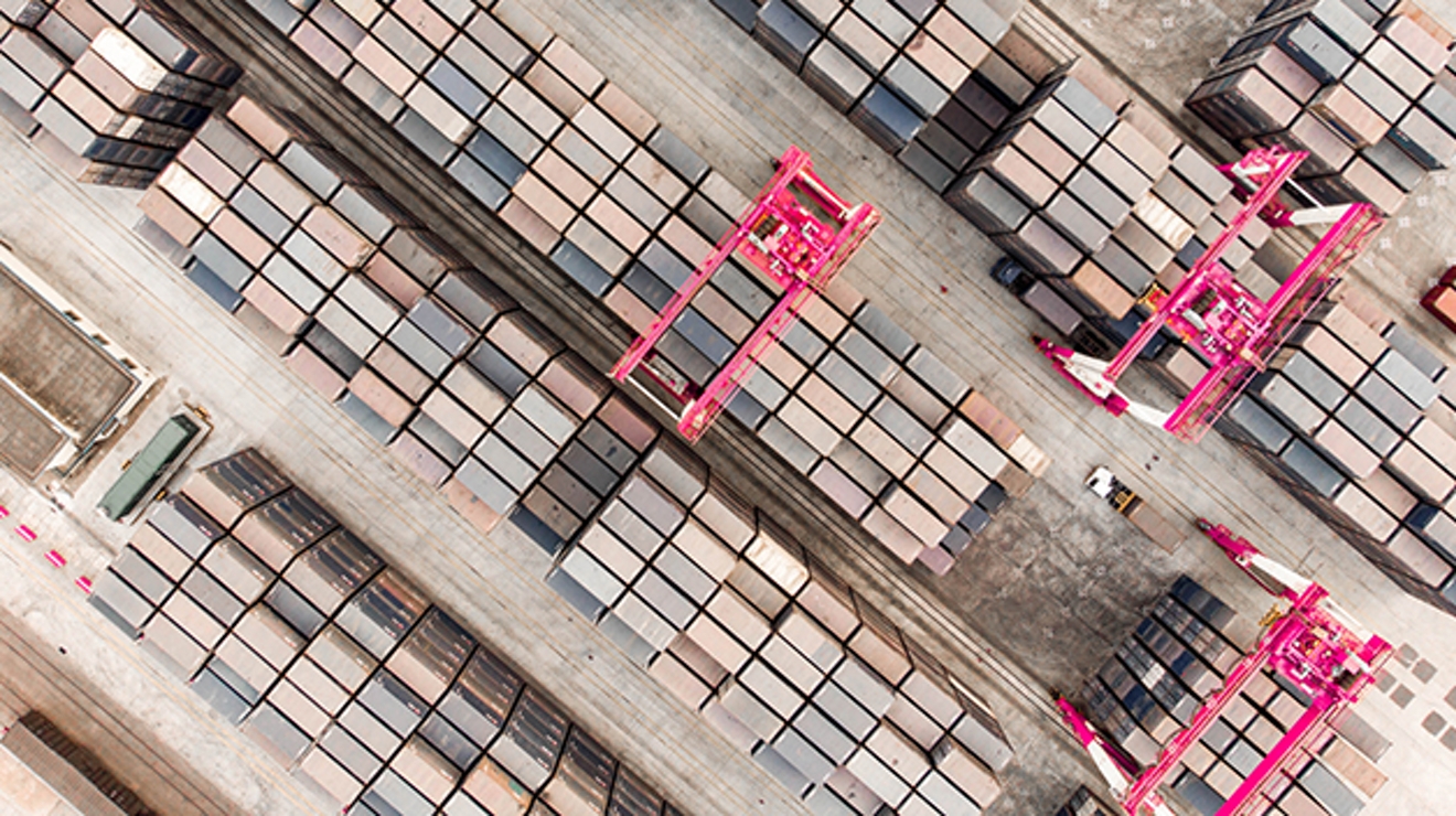 Robotic machinery above many rows of cargo containers