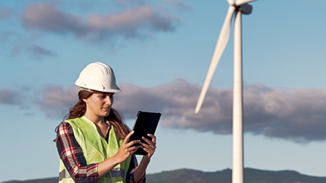 Woman with white helmet in front of wind turbine