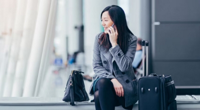 A professional takes a business call from an international airport.