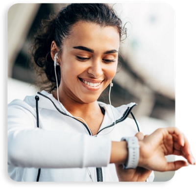 Woman looking at her watch and smiling.
