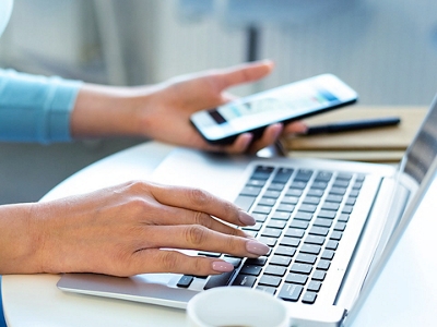 A person setting their Do Not Sell My Personal Information preference on their phone and laptop.