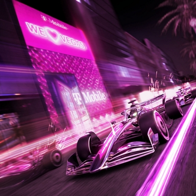 A sleek, shiny magenta racecar speeds around a track with a blurred background.