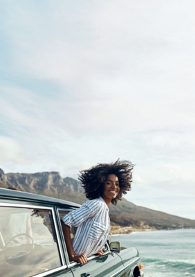 Woman smiling with her head out of a car