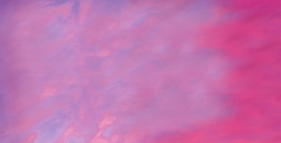 Pink and purple cotton candy sky with an Alaska Airlines plane flying in the distance
