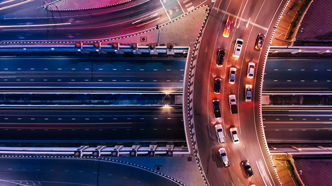 Overhead view of cars on curving highway.