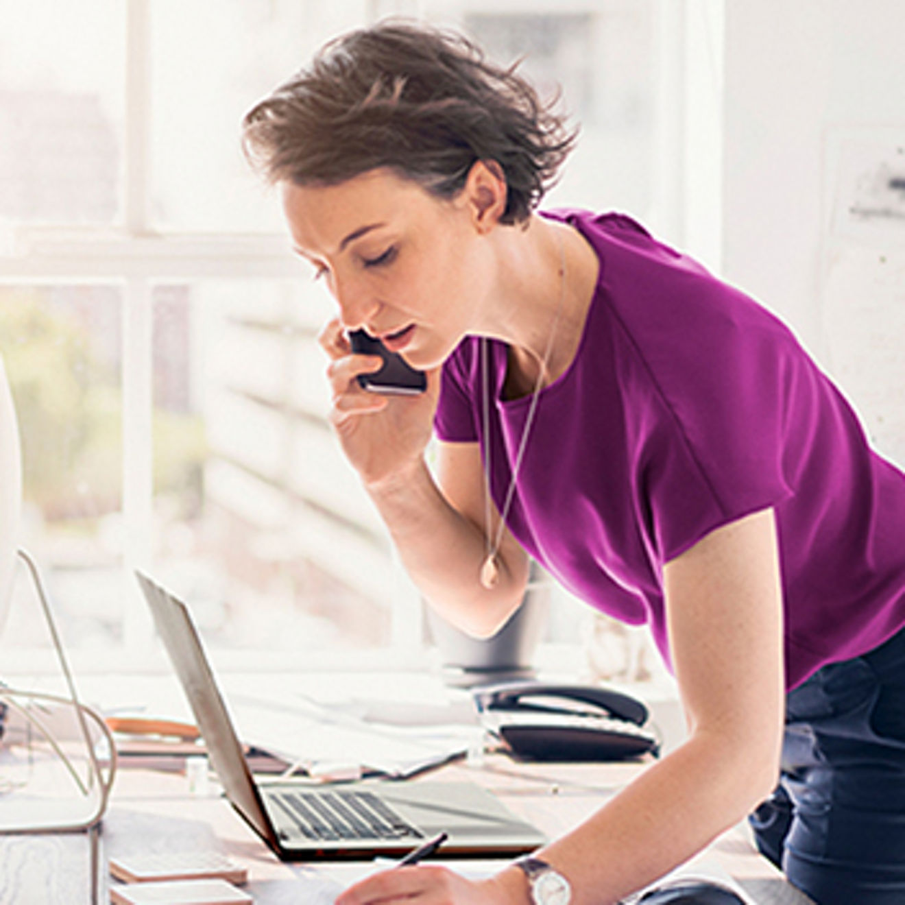 Woman on her phone at her desk