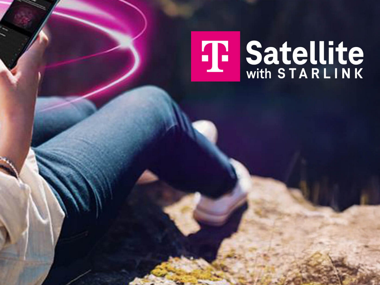 A hiker uses a phone on top of a mountain.