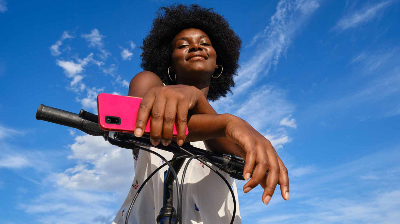 Image of a woman holding a cell phone riding a bike