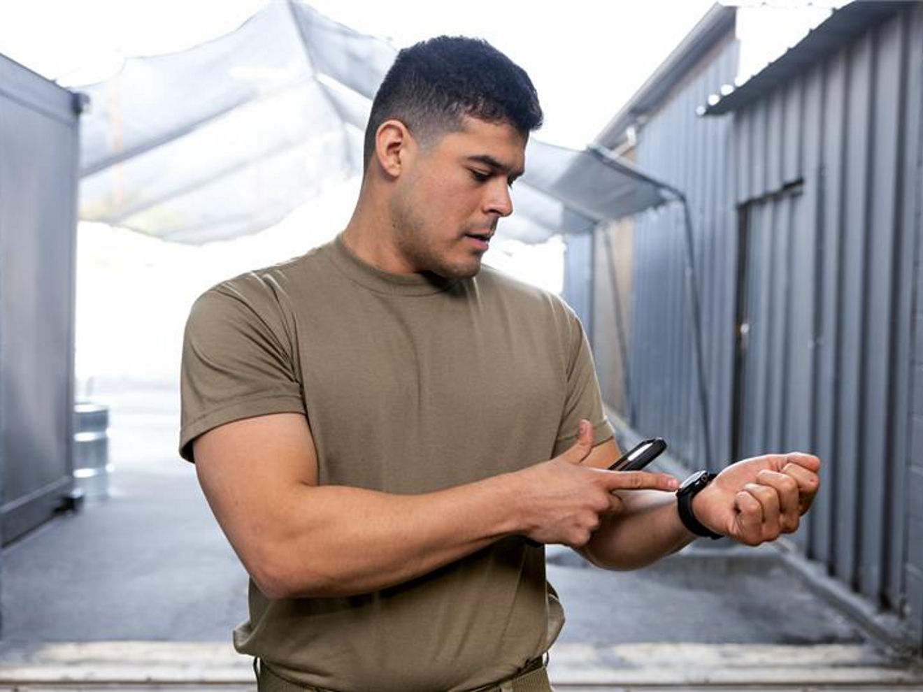 Soldier holding phone and pointing to his watch